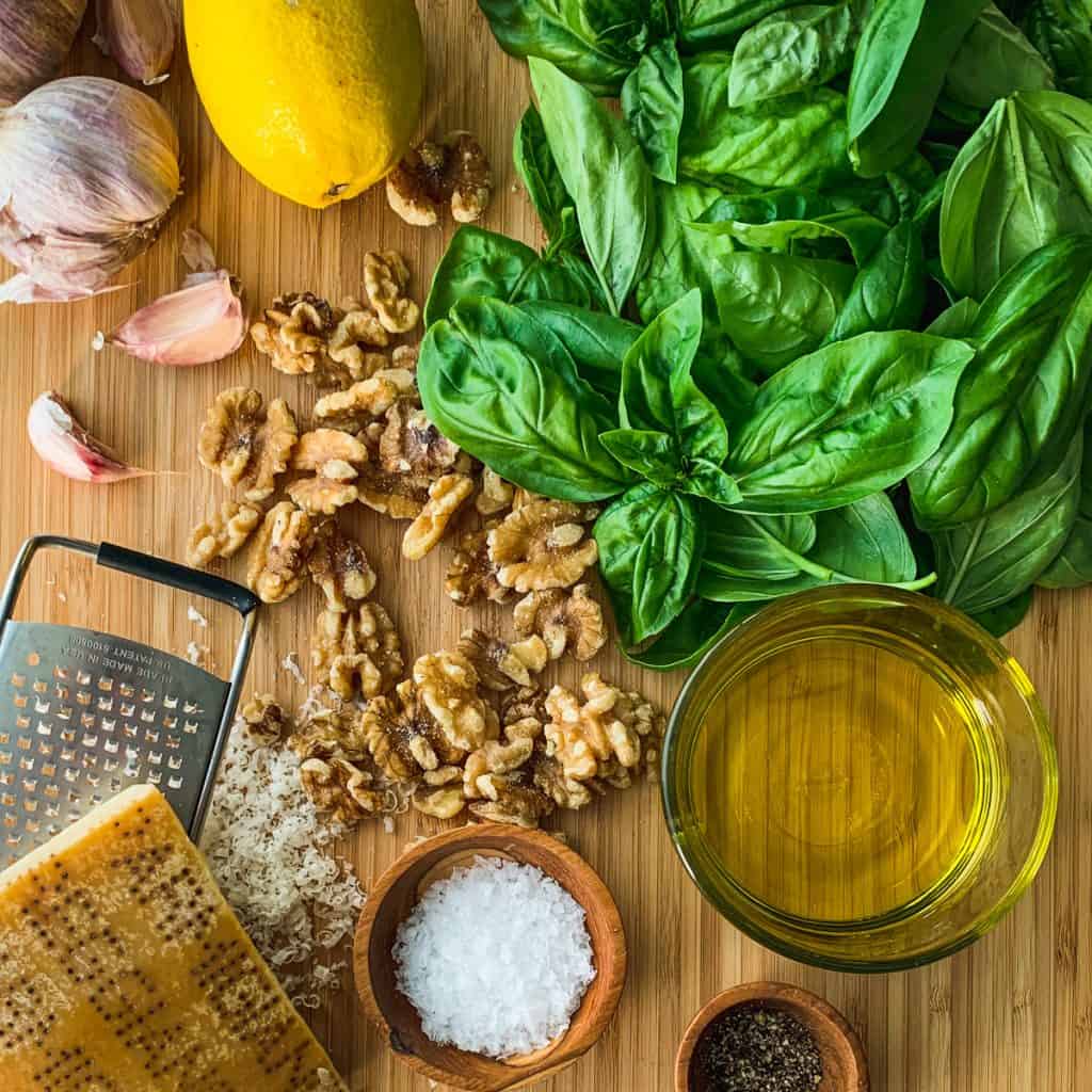 Assembled pesto ingredients on a board.