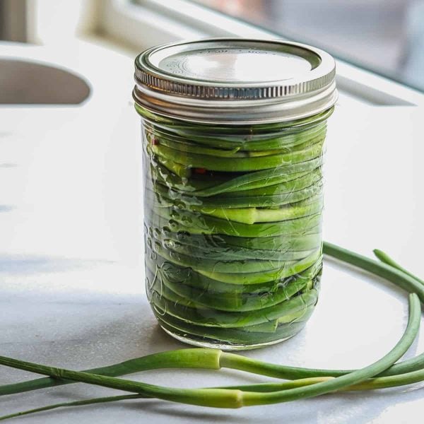 Pickled garlic scapes in a mason jar.
