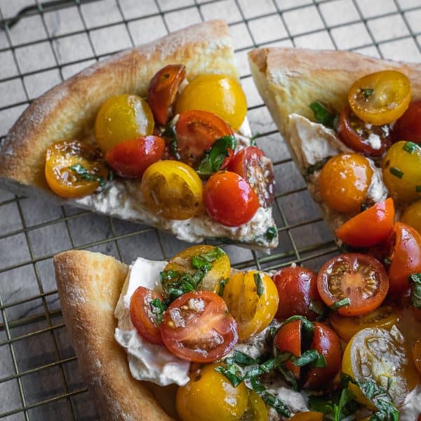 Bruschetta Pizza with burrata and cherry tomatoes sliced.