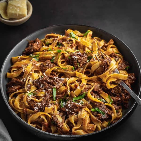 Short rib ragu in a small bowl with a fork.