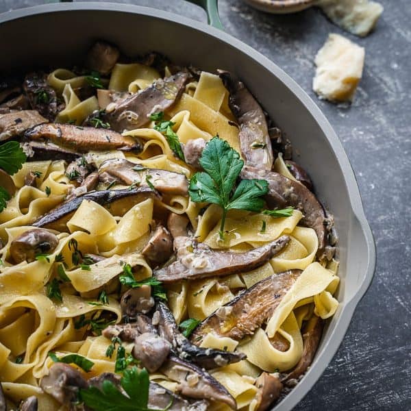 Mushrooms and pasta in a frying pan.