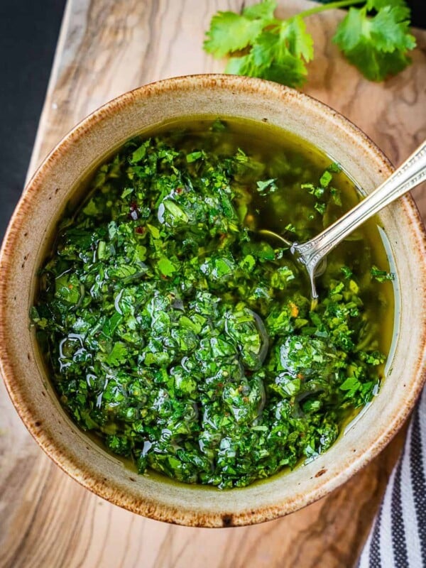 Cilantro chimichurri in a bowl with a spoon.