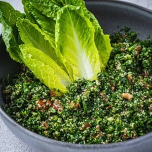 Tabbouleh salad in a bowl with romaine lettuce hearts.