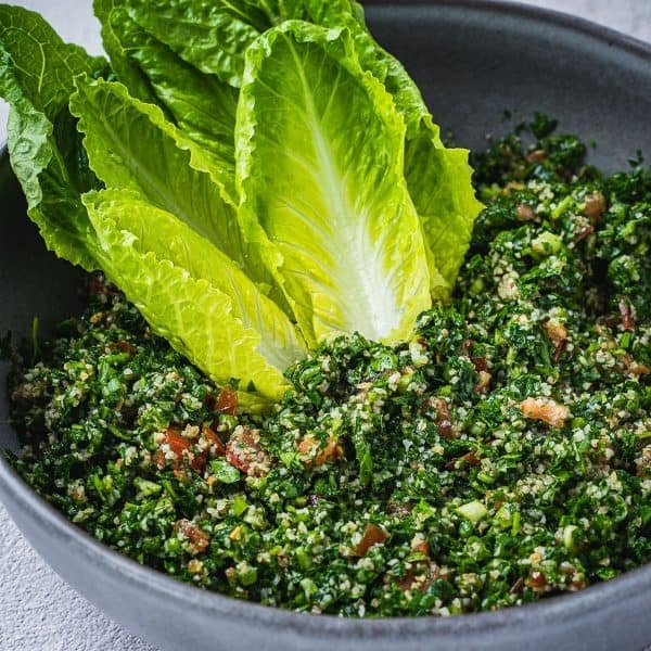 Tabbouleh salad in a bowl with romaine lettuce hearts.