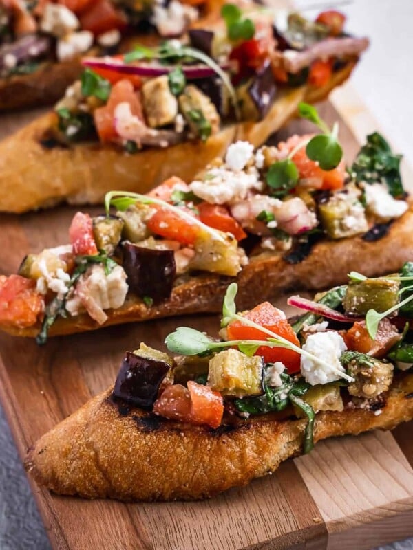 Toasted sliced baguette with eggplant and tomato topping.