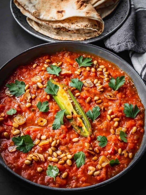 A plate with levantine fried tomatoes garnished with parsley.