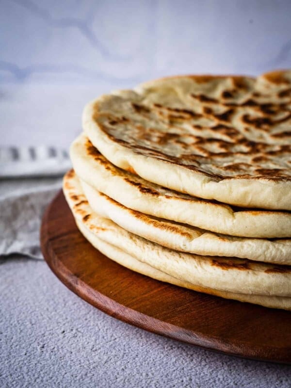 Stack of flatbread on a wooden board.