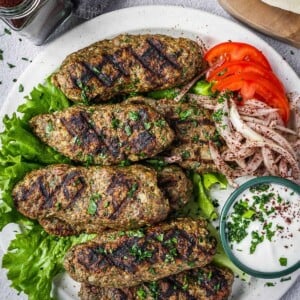 Beef kofta on a plate with a side of vegetables.