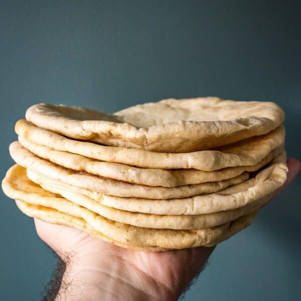 A stack of pita bread held in a hand.