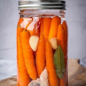 Fermented carrots, garlic, bay leaf and spices in a mason jar.