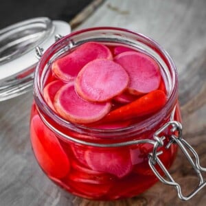 A jar with fermented pink radish slices.