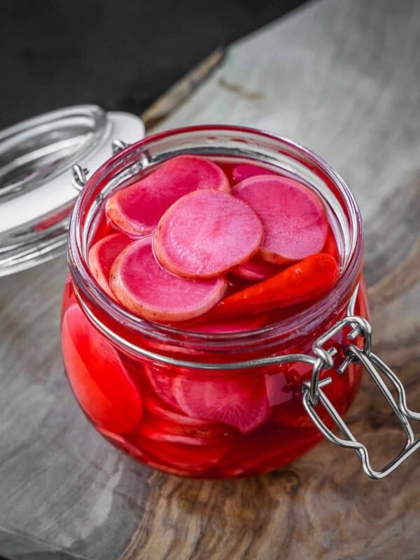 A jar with fermented pink radish slices.