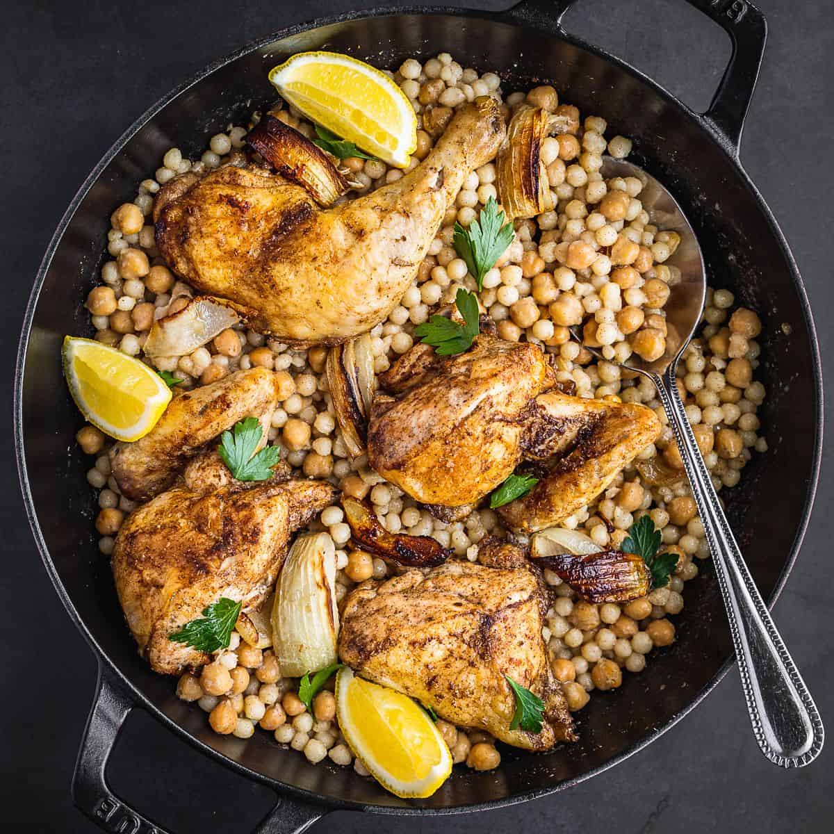 A pot with roasted chicken, onions and pearl couscous.