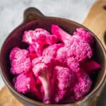 A bowl with pickled pink cauliflower florets.