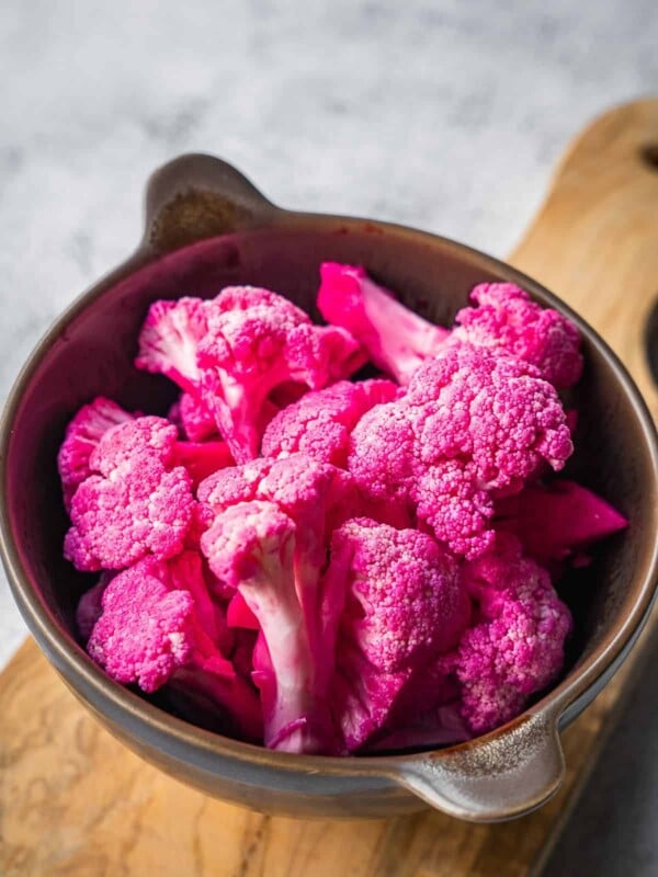 A bowl with pickled pink cauliflower florets.
