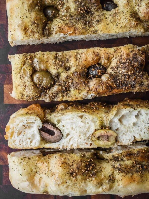 Sliced focaccia with za'atar spice and olives.