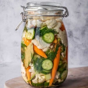 Large pickling crock filled with pickled Italian vegetables, herbs and spices.