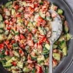 Bowl of tahini chopped salad with sumac garnish.