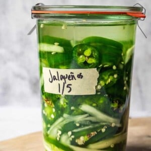 A Weck glass jar with sliced jalapenos and onions.