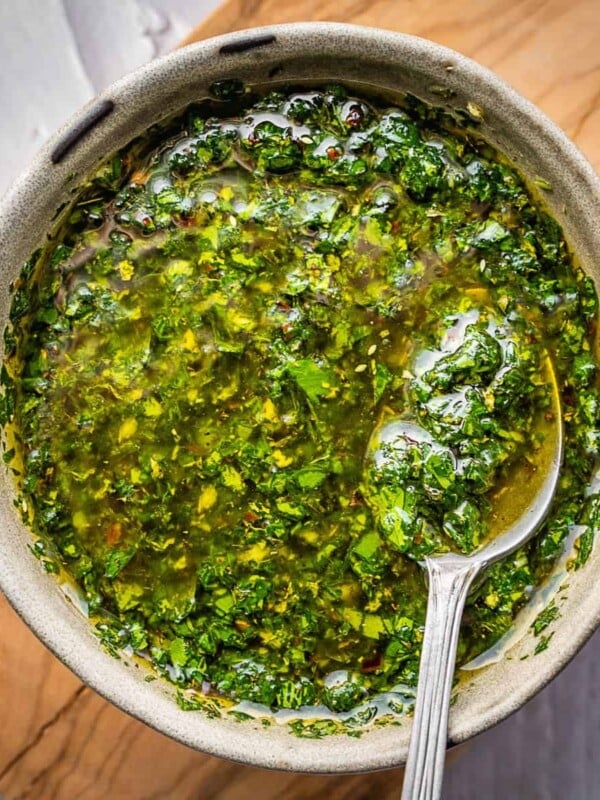 Mint chimichurri sauce in a bowl with a spoon.