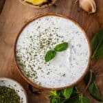 Mint yogurt sauce in a bowl with mint garnish.