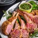 Pistachio-crusted rack of lamb carved and ready to serve with herb sauce.