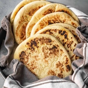 A bowl with a stack of freshly made Greek pitas.