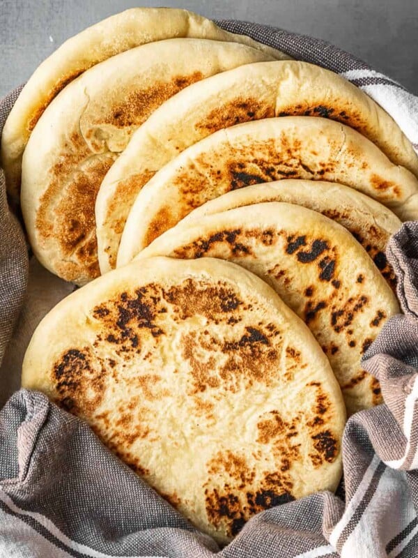 A bowl with a stack of freshly made Greek pitas.