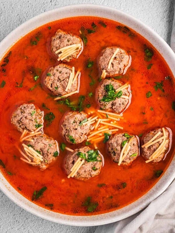 Bowl of kofta meatball soup with noodles in a tomato broth.