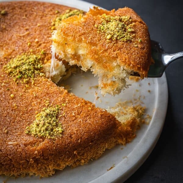 A slice of knafeh showing a cheese pull.