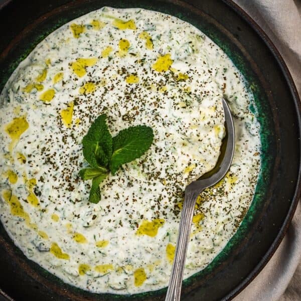 Turkish cacik in a bowl garnished with mint and olive oil.