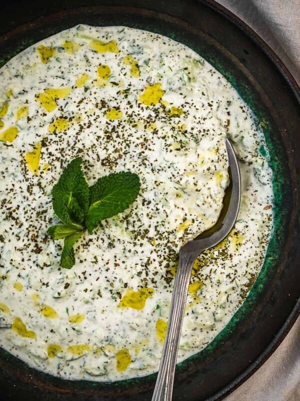 Turkish cacik in a bowl garnished with mint and olive oil.