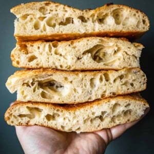Stack of sliced Schiacciata flatbread in a hand.