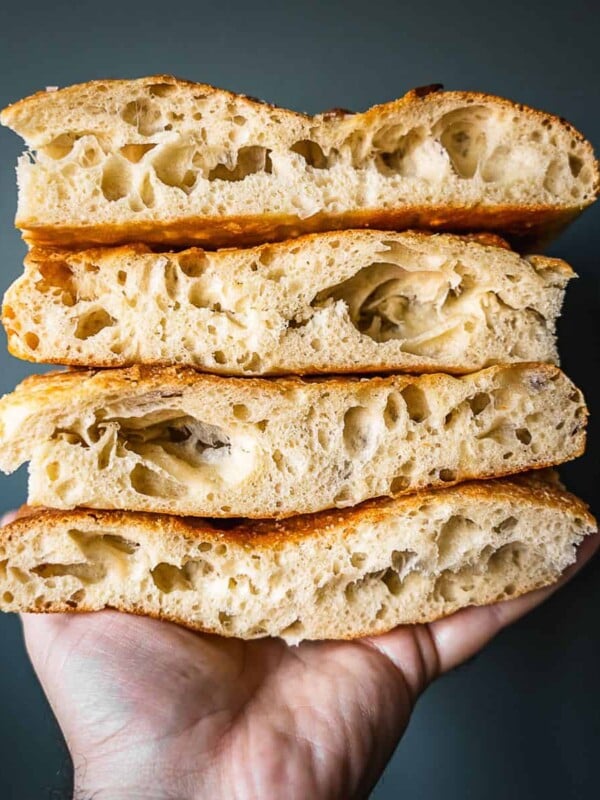Stack of sliced Schiacciata flatbread in a hand.