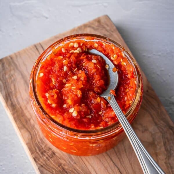 Fermented Sambal Oelek in a mason jar with a spoon.