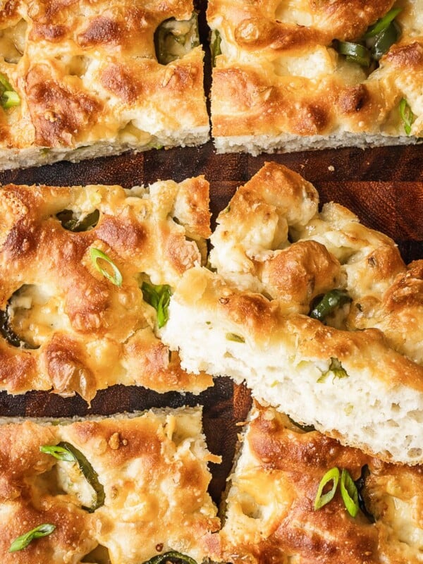 Slices of cheddar jalapeno focaccia on a wooden board.