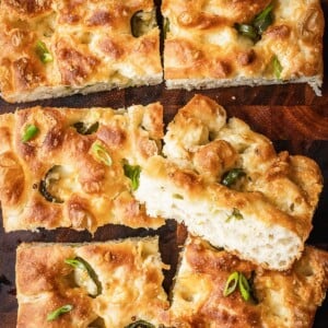 Slices of cheddar jalapeno focaccia on a wooden board.