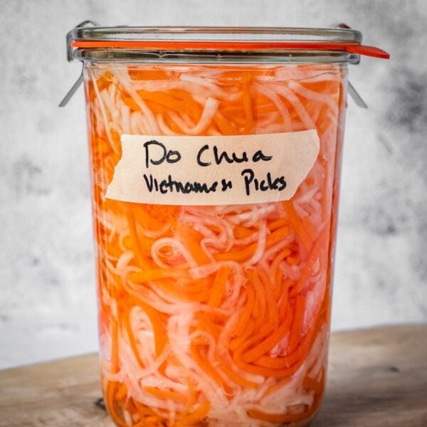 A sealed and labeled jar of do chua, Vietnamese pickled vegetables.