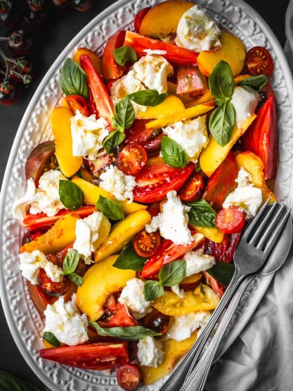Salad with sliced peaches, heirloom tomatoes, basil, and mozzarella.