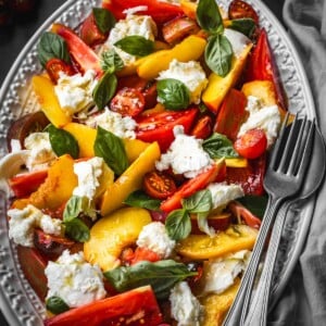 Peach caprese salad with sliced peaches, heirloom tomatoes, basil and mozzarella.