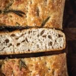 Sliced whole wheat focaccia on a wood cutting board.