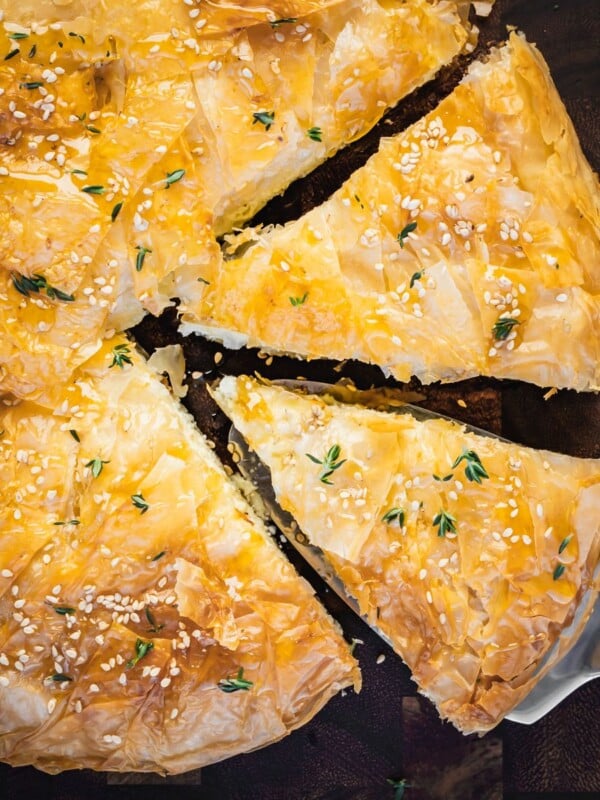 Greek cheese pie slices on a wooden board.