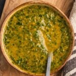 A bowl of North African Chermoula sauce on a wooden board.