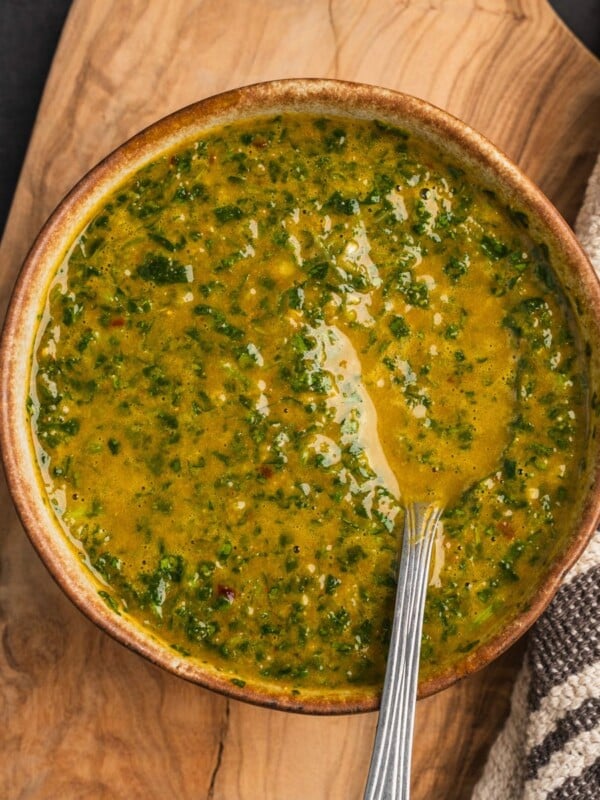 A bowl of North African Chermoula sauce on a wooden board.