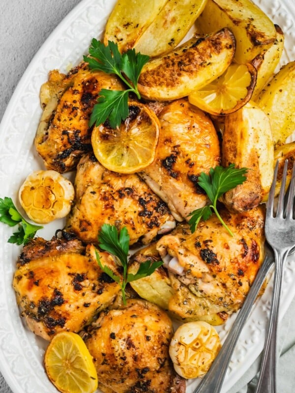 Greek lemon chicken and potatoes in a baking tray.