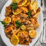 Greek chicken and potatoes in a serving dish.