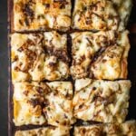 Caramelized Onion Gruyere Focaccia slices on a board.