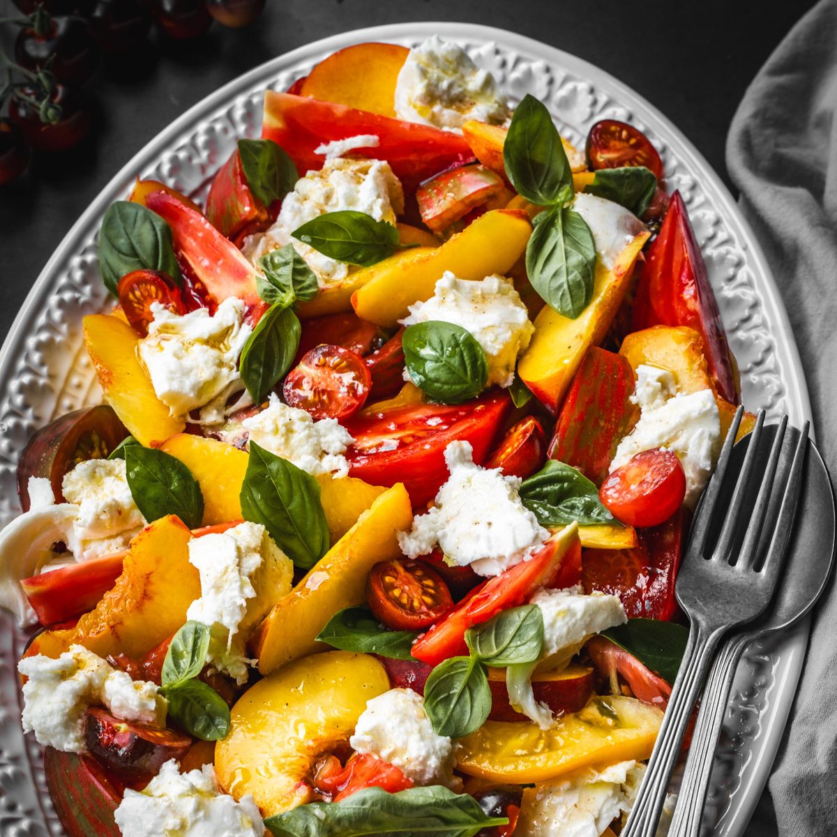 Platter with peach, tomato and cheese slices.