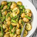 Asparagus pea potato salad in a large serving bowl garnished with dill.