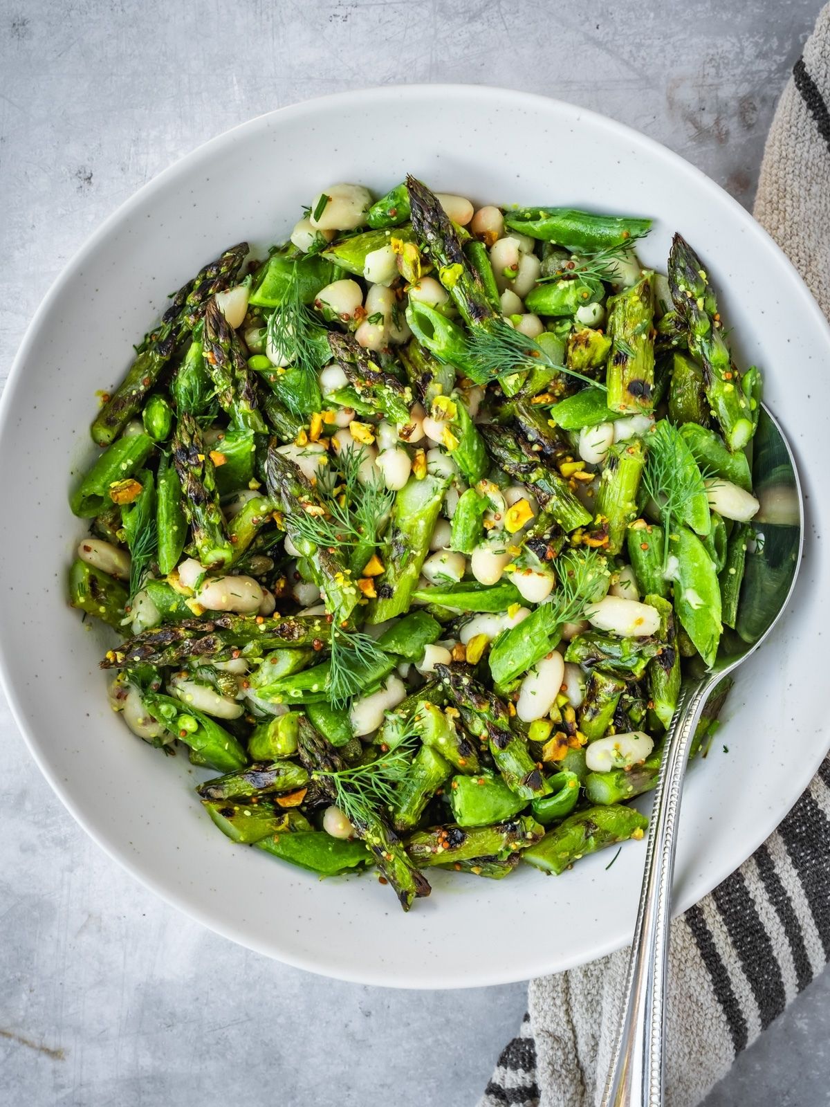 Grilled asparagus and white bean salad in a large bowl.